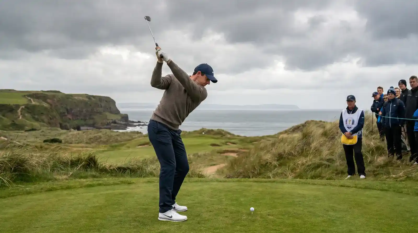The Open Championship tee shot with links course and coastal backdrop