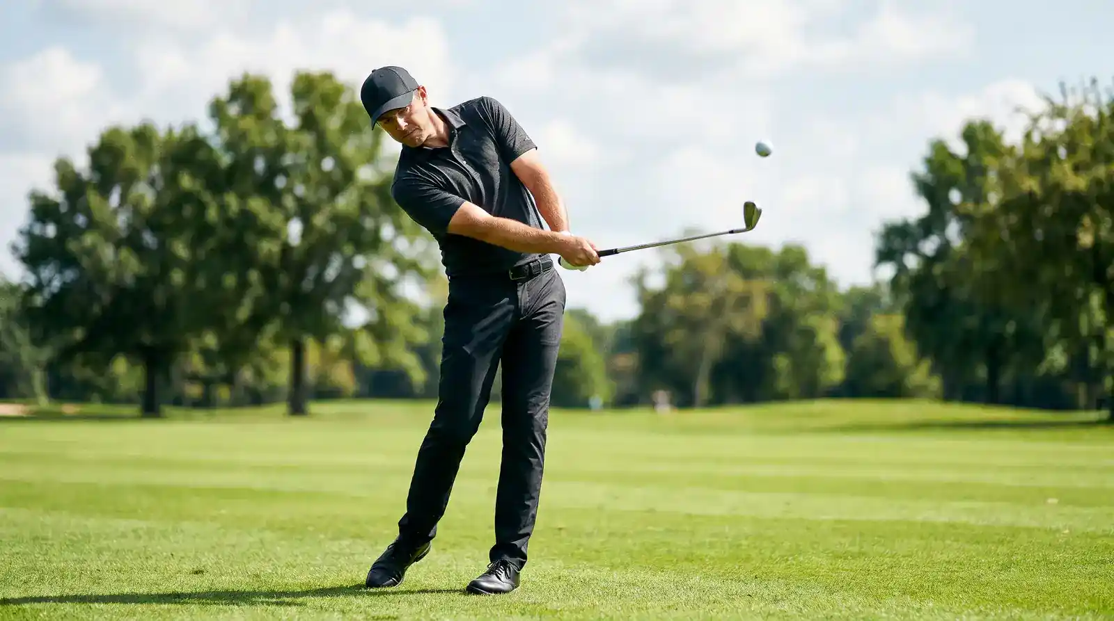 Professional golfer hitting a precise iron shot from the fairway illustrating tee-to-green Strokes Gained performance